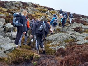 A group of young people walking on a mountain trail