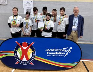 Jack Petchey Foundation Trustee Ron Mills celebrating with a group of seven SEND young people at a Panathlon event